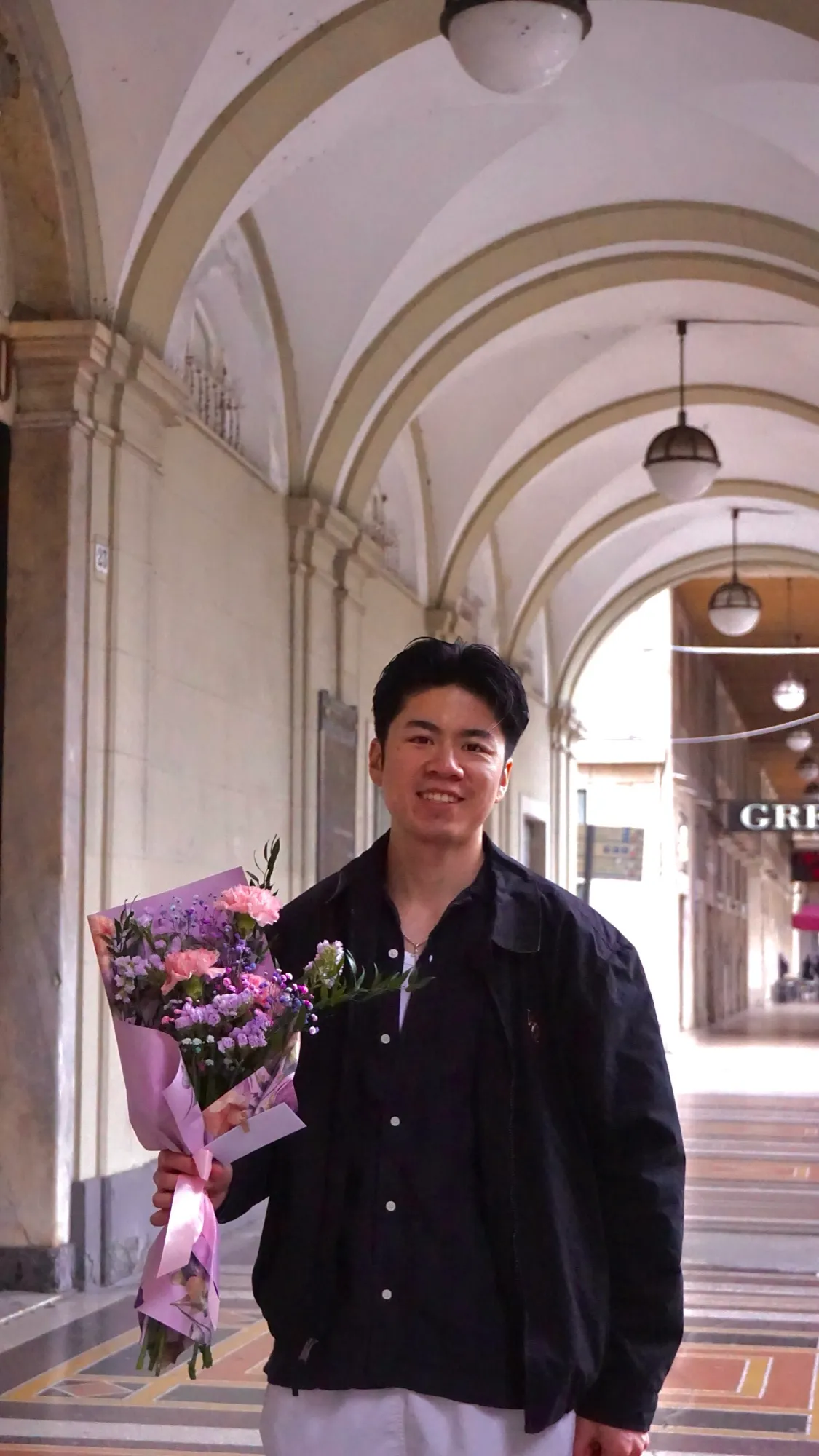 Duong mit einem Blumenstrauß unter hellen Arkaden