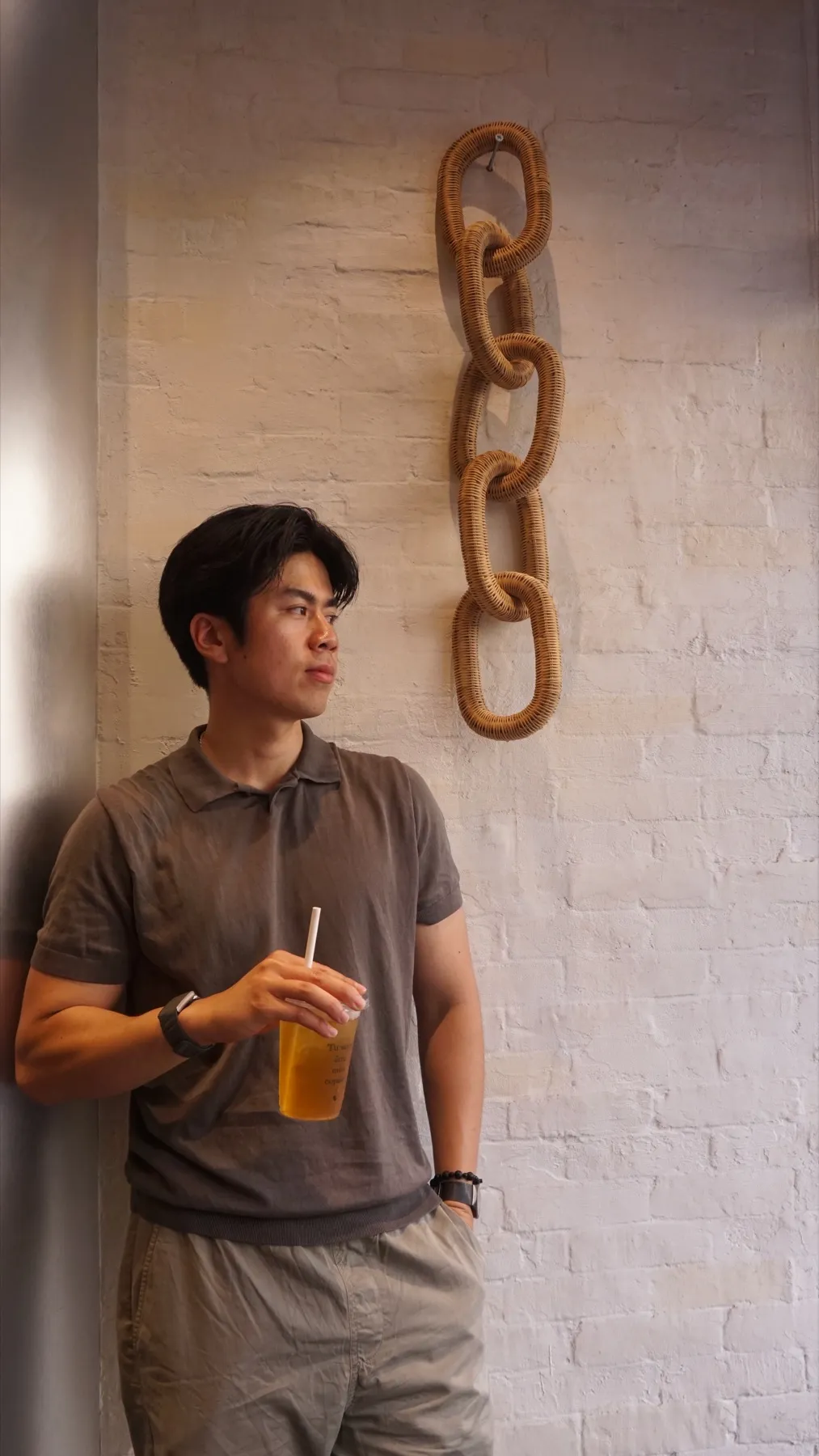 Duong entspannt an einer hellen Wand
